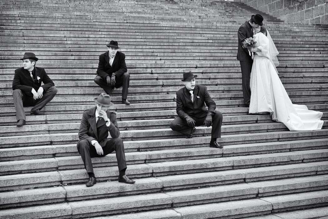Друзья жениха сидят на широких больших ступеньках рядом с женихом и невестой, свадьба в стиле "Чикаго" - фото 859893 Фото и видеосьёмка Studio Proffit