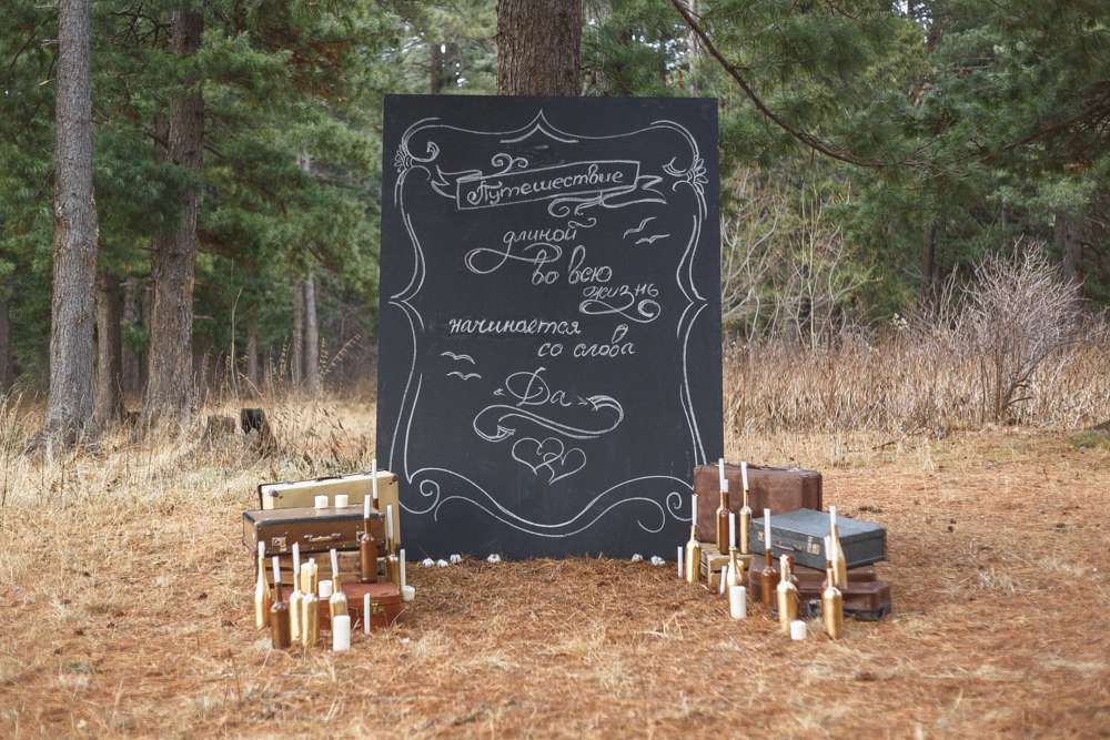Черная доска с надписями, возле дерева, чемоданов, коробок и бутылок,  - фото 3247661 Свадебный стилист Ирина Дядькина