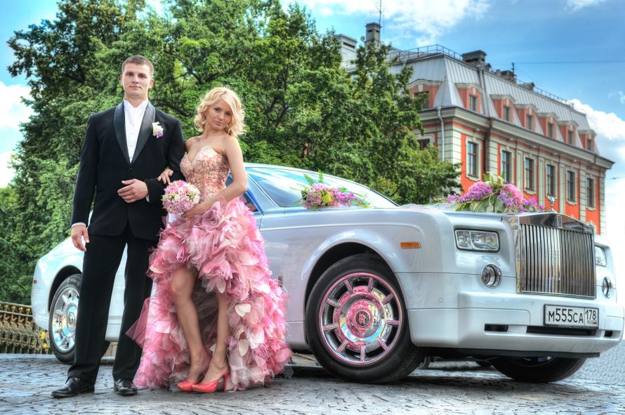 Серебристый ""Rolls-Royce"" на фоне городских зданий, украшенный розовыми экибанами , рядом с парой молодоженов. - фото 951787 Свадебный фотограф в Санкт-Петербурге