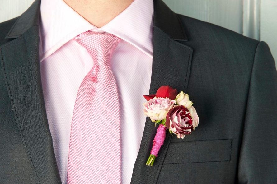 Бутоньерка из бордовой, красной, розовой и белых эустом, декорированная розовой атласной лентой, в петлице черного пиджака - фото 1447019 Студия цветов "101 роза"