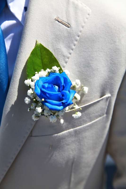 Бутоньерка из синей розы, белых цветов гипсофилы и зеленого листа, в  петлице серого пиджака   - фото 1613536 Exclusivaweddings - организация свадьбы на Санторини