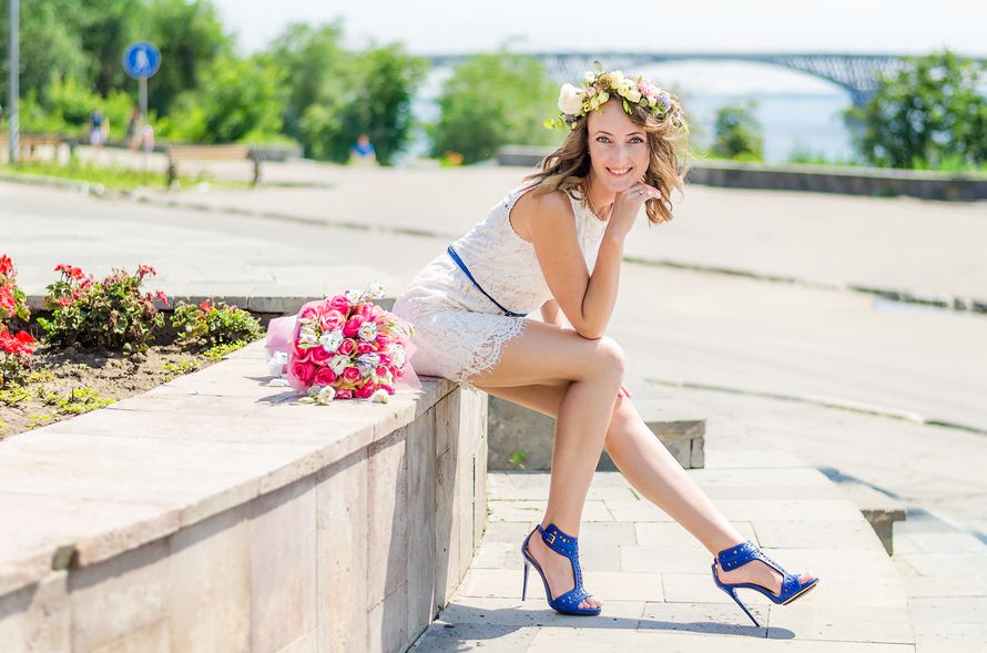 Невеста в белом платье с синим пояском и синими босоножками на высоком каблуке, сидит возле клумбы с букетом цветов.  - фото 2636939 Фотограф Нина Дубровина
