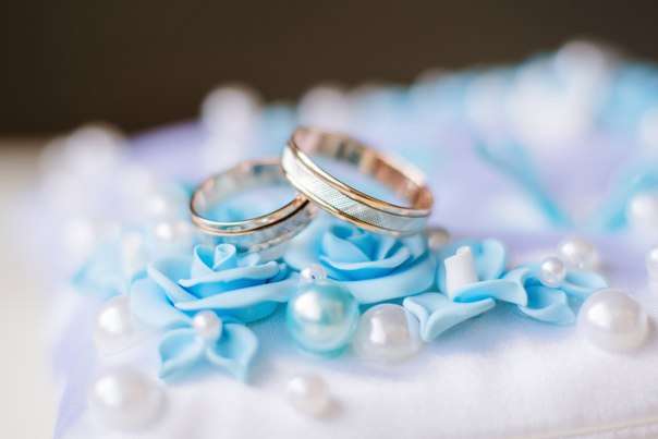 Обручальные кольца из комбинированного золота с бороздками на фоне голубых розочек и бусин. - фото 3144483 Свадебные aксессуары Лады Зайцевой