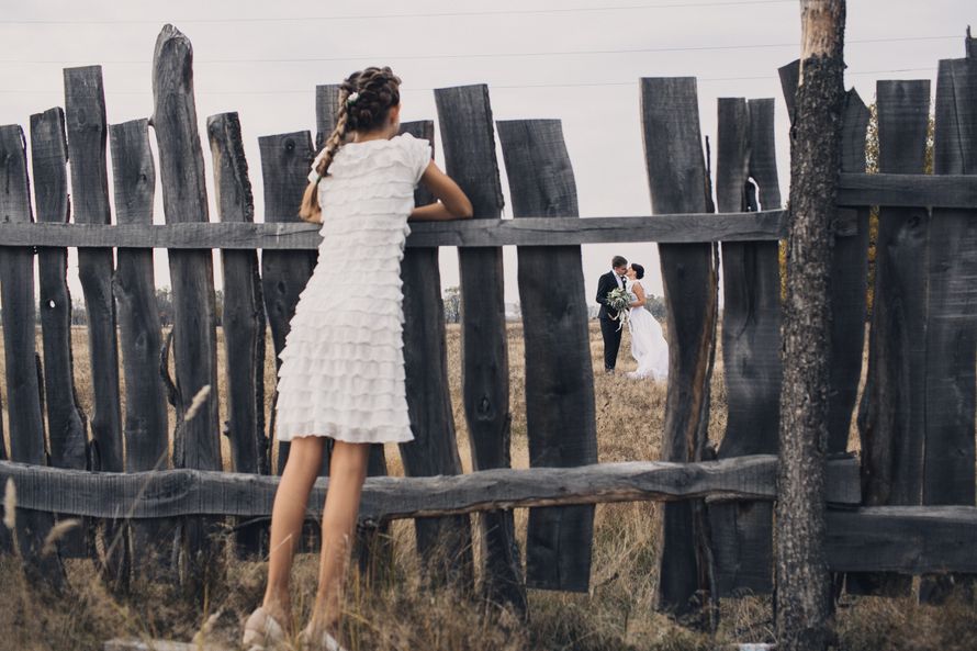 Девушка смотрит на жениха и невесту сквозь щель в заборе  - фото 3269567 Фотограф Елена Горина