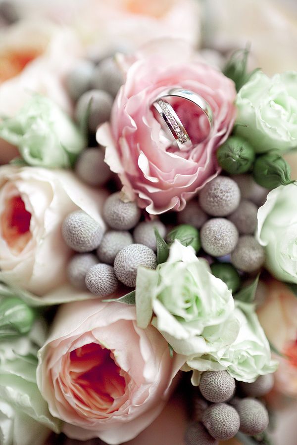 Обручальные кольца, одно из которых с бриллиантами и гравировкой на фоне букета цветов. - фото 1775205 Teplo Event Bureau