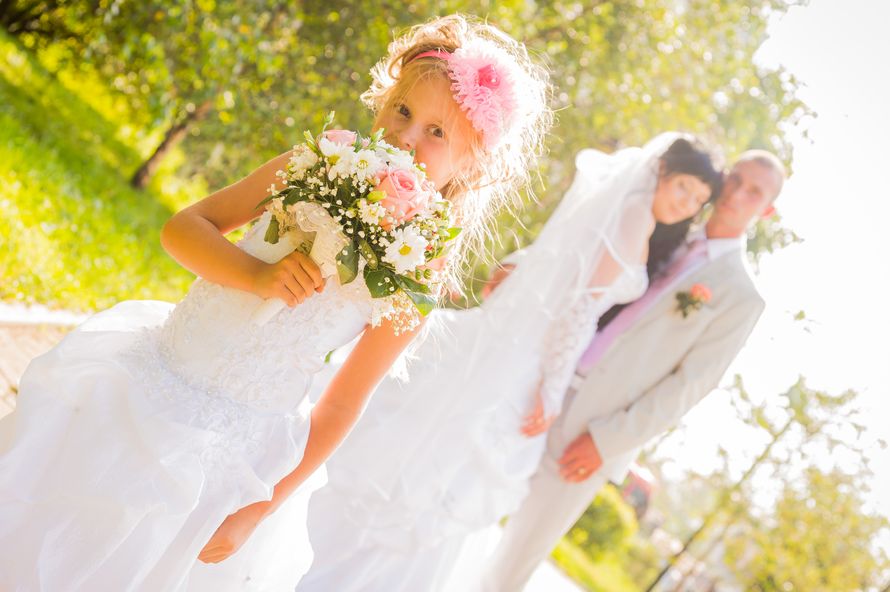Девочка в солнечный день на прогулке с женихом и невестой в белом шикарном  платье держит красивый свадебный букет - фото 2301836 Фотограф Вандин Сергей