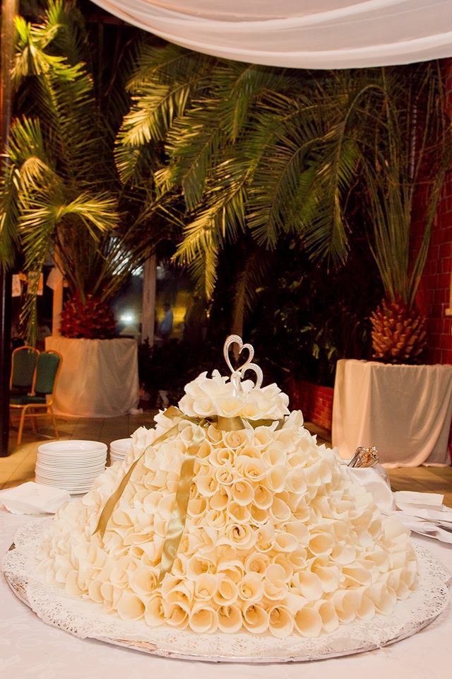 Большой свадебный торт  оранжевого цвета, украшен золотой ленточкой, сверху два сердца. - фото 2419759 Irina Gruzdeva