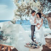 Свадебные объятия на берегу моря возле мольберта