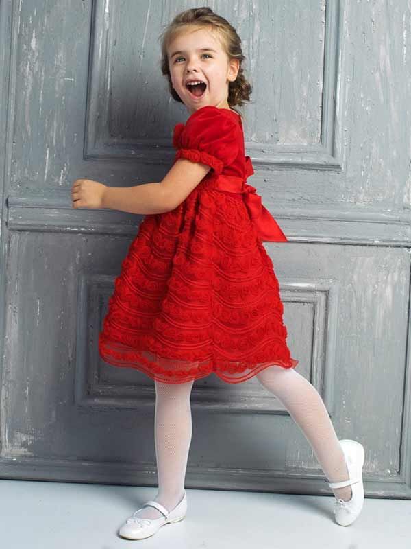 Девочка идет у старинной серой двери в красном  праздничном платье - фото 1569239 "Светлая чайка" - cвадебный салон