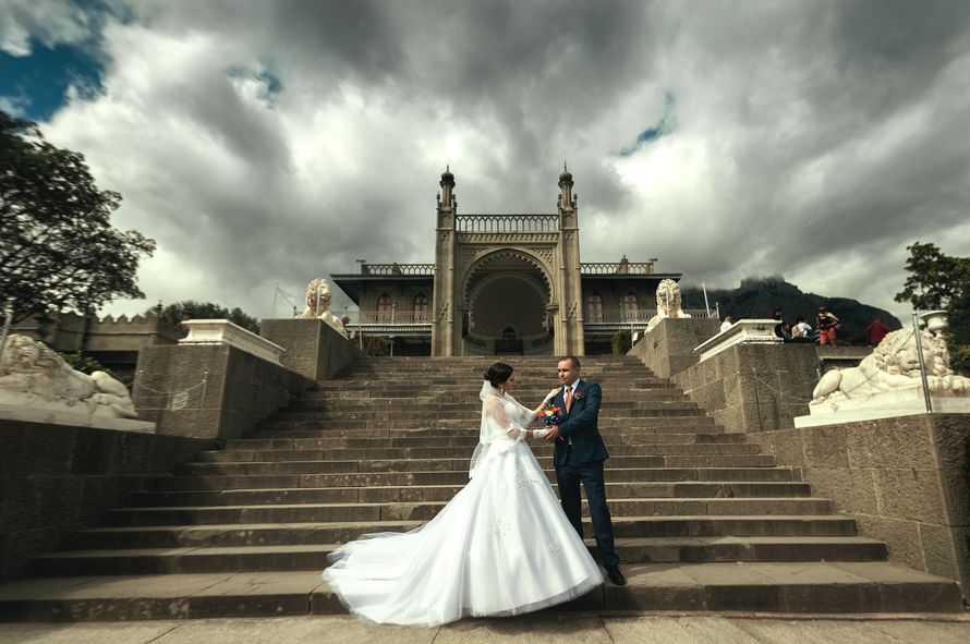 Жених и невеста, взявшись за руки, стоят на серых ступеньках - фото 3238217 Фотограф Евгений Иванов