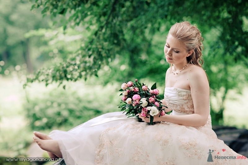 Невеста в белом длинном платье сидит с букетом цветов в лесу - фото 56676 роза ветров