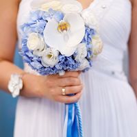 Букет невесты из голубых гортензий, белых эустом и белых орхидей, декорированный ярко-голубой лентой и веревкой 