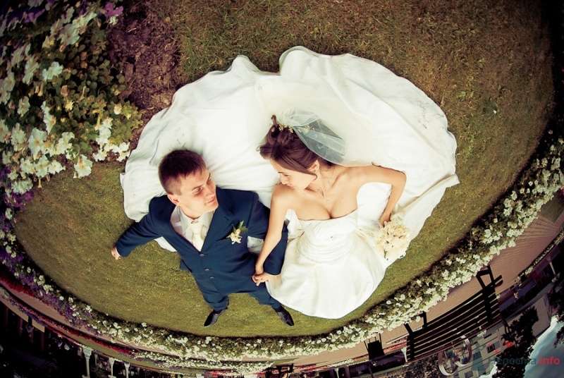 Жених и невеста, взявшись за руки, лежат на траве  - фото 50337 Sabinulya