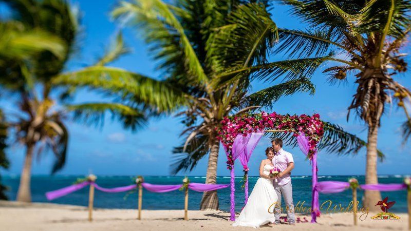 Возле свадебного шатра, украшенного сиреневой тканью и цветами, стоят молодожены, жених в светлых брюках и розовой рубашке - фото 3418451 Caribbean Wedding - свадьба в Доминикане