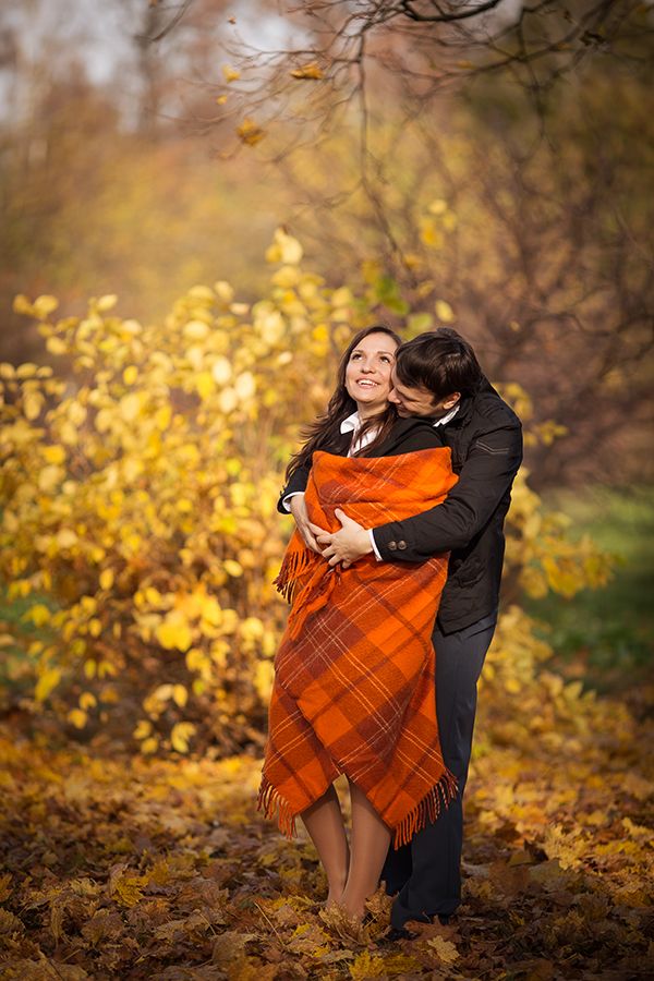 Жених и невеста, укрывшись оранжевым клетчатым пледом, стоят на фоне осенних деревьев - фото 1300833 Фотограф Анна Ткачева