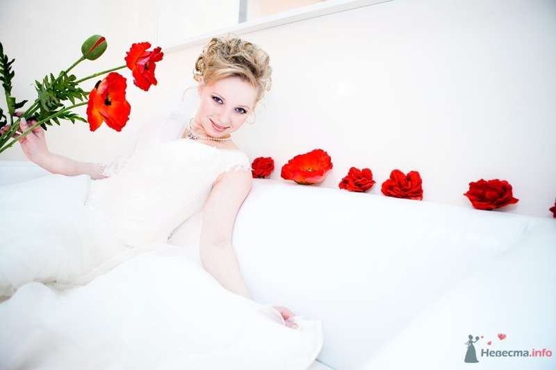 Невеста сидит на белом диване, который  украшен красными цветами - фото 61802 Танюхин